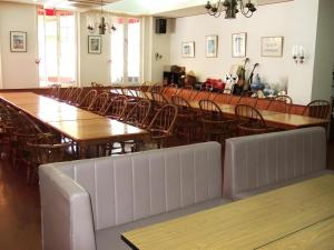 a dining room with wooden tables and chairs at Petit Hotel Key West Club in Inbu