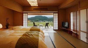 a bedroom with a bed and a television and a view at Shiratamano Yu Kahou in Shibata