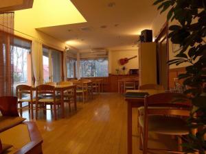 ein Restaurant mit Holztischen und Stühlen in einem Raum in der Unterkunft Pension Twilight in Nasu-yumoto