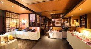 ein Restaurant mit zwei Tischen und weißen Tischdecken in der Unterkunft Hotel Naito Kofu Showa in Showa