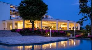 un grand bâtiment blanc avec un étang en face dans l'établissement Hotel Harvest Hamanako, à Hamamatsu 158 autres photos