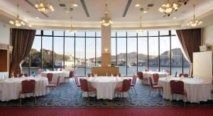 a banquet hall with tables and chairs and large windows at Green Hill Hotel Onomichi in Kaneyoshi +98 photos
