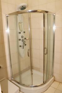 a shower with a glass door in a bathroom at Hotel Residence Flamani in Lomé