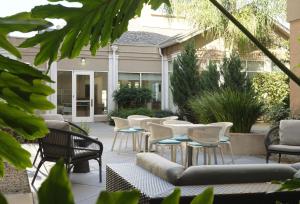 un groupe de chaises et de tables sur une terrasse dans l'établissement Hilton Garden Inn San Jose/Milpitas, à Milpitas 40 autres photos