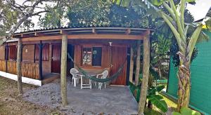 a gazebo with a hammock outside of a house at Pousada Maktub in Guarda do Embaú