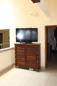 a flat screen tv sitting on top of a wooden entertainment center at Hotel Residence Flamani in Lomé
