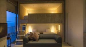 ein Schlafzimmer mit einem Bett und eine Treppe mit einem Balkon in der Unterkunft MISAKI TERRACE in Ako