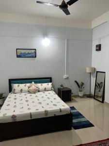 a bedroom with a bed and a ceiling fan at Puhor Inn in Sivasagar +9 photos