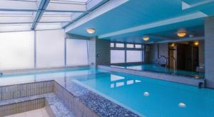 une grande piscine avec de l'eau bleue dans un immeuble dans l'établissement Ikebukuro Royal Hotel, à Tokyo