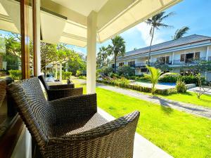 a porch with wicker chairs and a view of a yard at Blue Opal Hotel in Amed