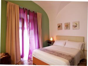 - une chambre avec un lit et une fenêtre avec des rideaux violets dans l'établissement Apartamentos La Machacona Plaza de Santiago, à Cáceres