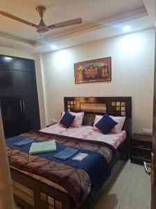 a bedroom with a large bed with blue pillows at 2 BHK Apartment, Jalandhar in Jalandhar