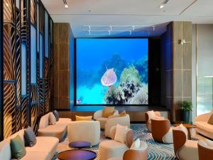 a large screen in a room with couches and an aquarium at Seafest Hotel Semporna in Semporna