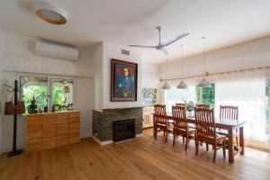 PURA VIDA - Amazing Villa with 4 bedrooms for up to 11 guests close to beach في بونتا دل إستي: غرفة طعام مع طاولة وكراسي ومدفأة