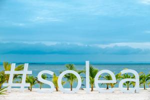 a sign on the beach with the ocean in the background at Solea Seaview Resort in Mactan