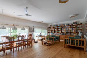 PURA VIDA - Amazing Villa with 4 bedrooms for up to 11 guests close to beach في بونتا دل إستي: غرفة معيشة مع طاولة وكراسي ومكتبة