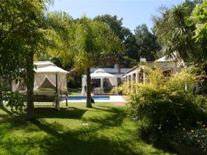 PURA VIDA - Amazing Villa with 4 bedrooms for up to 11 guests close to beach في بونتا دل إستي: حديقة فيها خيمة ومسبح