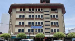 un grand bâtiment avec des voitures garées devant dans l'établissement OYO 969 Hotel Pantai View, à Victoria