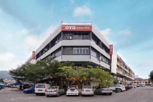 un grand bâtiment avec des voitures garées dans un parking dans l'établissement OYO 90118 Suntex Hotel, à Kampong Baharu Cheras Batu Sembilan
