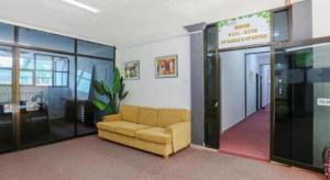 a lobby with a couch in a room with glass walls at OYO 89922 The Sarina Hotel & Cafe in Kampong Bukit Susun