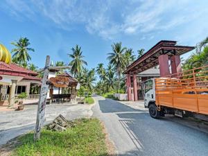 ein LKW, der vor einem Gebäude parkt in der Unterkunft OYO 90278 Redzwan's Beach Resort in Kampong Sungai Dua