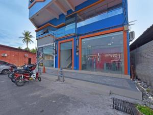 eine Gruppe von Motorrädern, die außerhalb eines Ladens geparkt werden in der Unterkunft OYO 90594 Hotel Casalink in Kampong Gong Gemia