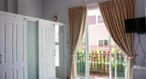 Zimmer mit einem Fenster mit Vorhängen und einem Balkon in der Unterkunft Baan Taklom Chomtalay in Ban Sahakham