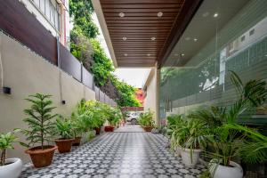 a hallway with potted plants in a building at swastik stays in Prayagraj