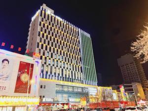 a tall building with lights on in a city at night at Jinjiang Inn Select Xinji Xinghua Road in Xinji