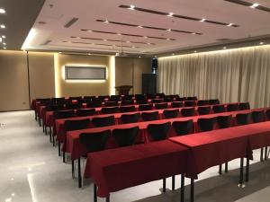 a conference room with red chairs and a screen at Jinjiang Inn Select Xinji Xinghua Road in Xinji