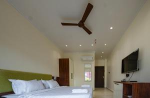 a bedroom with a bed and a ceiling fan at swastik stays in Prayagraj