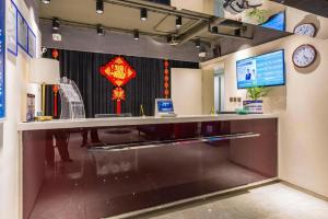 ein Büro mit einem Schreibtisch mit einem Computer und einer Uhr in der Unterkunft Jinjiang Inn Select Beijing Miyun Development Zone in Miyun