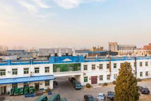 eine Gruppe von Gebäuden mit auf einem Parkplatz geparkten Autos in der Unterkunft Jinjiang Inn Select Beijing Miyun Development Zone in Miyun