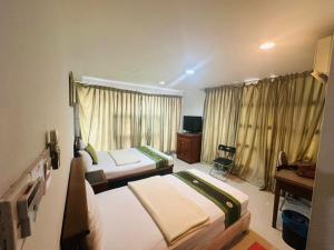 a hotel room with two beds and a television at J Hotel Bukit Bintang in Kuala Lumpur