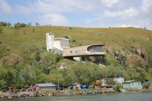 a house on top of a hill next to the water at Sevan Writers House in Sevan