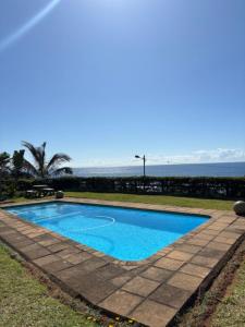 a blue swimming pool with the ocean in the background at Coral Reef 502 in La Mercy