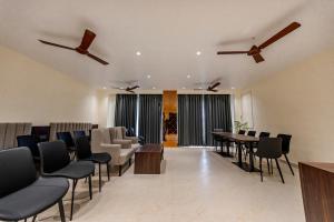 a dining room with chairs and a table and ceiling fans at swastik stays in Prayagraj