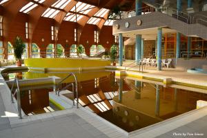 a large building with a pool of water in it at Tisia Hotel & Spa in Tiszaújváros +103 photos