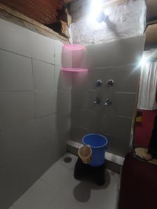 - une petite salle de bains avec un seau bleu dans l'établissement Organic styas manali, à Nagar