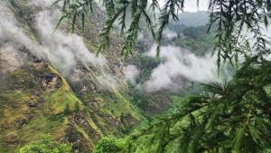 une vue d'une montagne avec des nuages dessus dans l'établissement Organic styas manali, à Nagar 8 autres photos