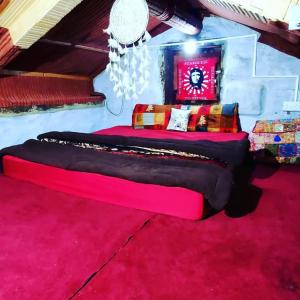 - une chambre avec un grand lit et un tapis rouge dans l'établissement Organic styas manali, à Nagar