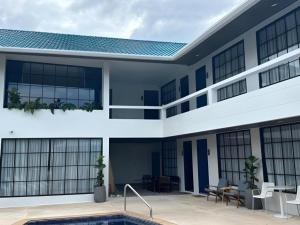 an exterior view of a building with a swimming pool at Calm Kamala Phuket in Kamala Beach