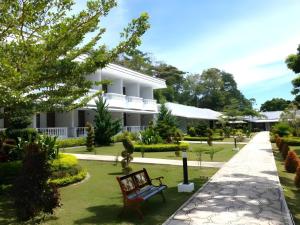 einem Park mit einer Bank vor einem Gebäude in der Unterkunft Toba Beach Hotel in Tomok