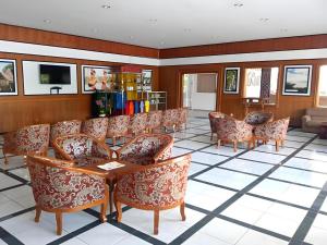 ein Wartezimmer mit Stühlen und einem Tisch in einem Gebäude in der Unterkunft Toba Beach Hotel in Tomok