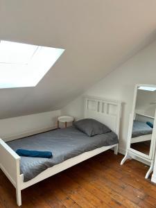 a bedroom with a white bed and a window at jolie maison de ville proche bords de Loire in Châteauneuf-sur-Loire