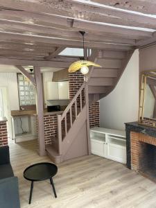 a living room with a staircase and a table at jolie maison de ville proche bords de Loire in Châteauneuf-sur-Loire