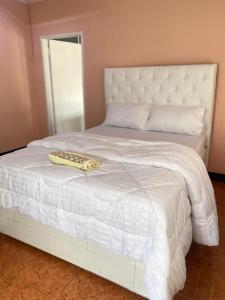 ein weißes Bett mit Fernbedienung darüber in der Unterkunft Lajoy Executive Lodge in Lusaka