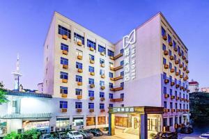 ein Hotel mit einem Schild an der Seite in der Unterkunft GME NanJing CaoChanGMEn Nanyihou Stress Hotel in Nanjing