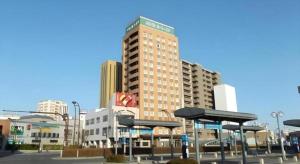 un grand bâtiment au milieu d'une ville dans l'établissement Hotel Route Inn Hirosaki Ekimae, à Hirosaki