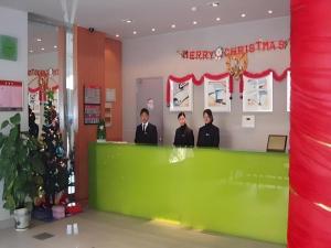 drei Männer stehen an einer grünen Theke in einem Geschäft in der Unterkunft JinJiang Inn Nanjing The Confucius Temple Zhonghuamen Metro Station in Nanjing